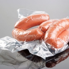 Vacuum-packed smoked sausages in plastic casings